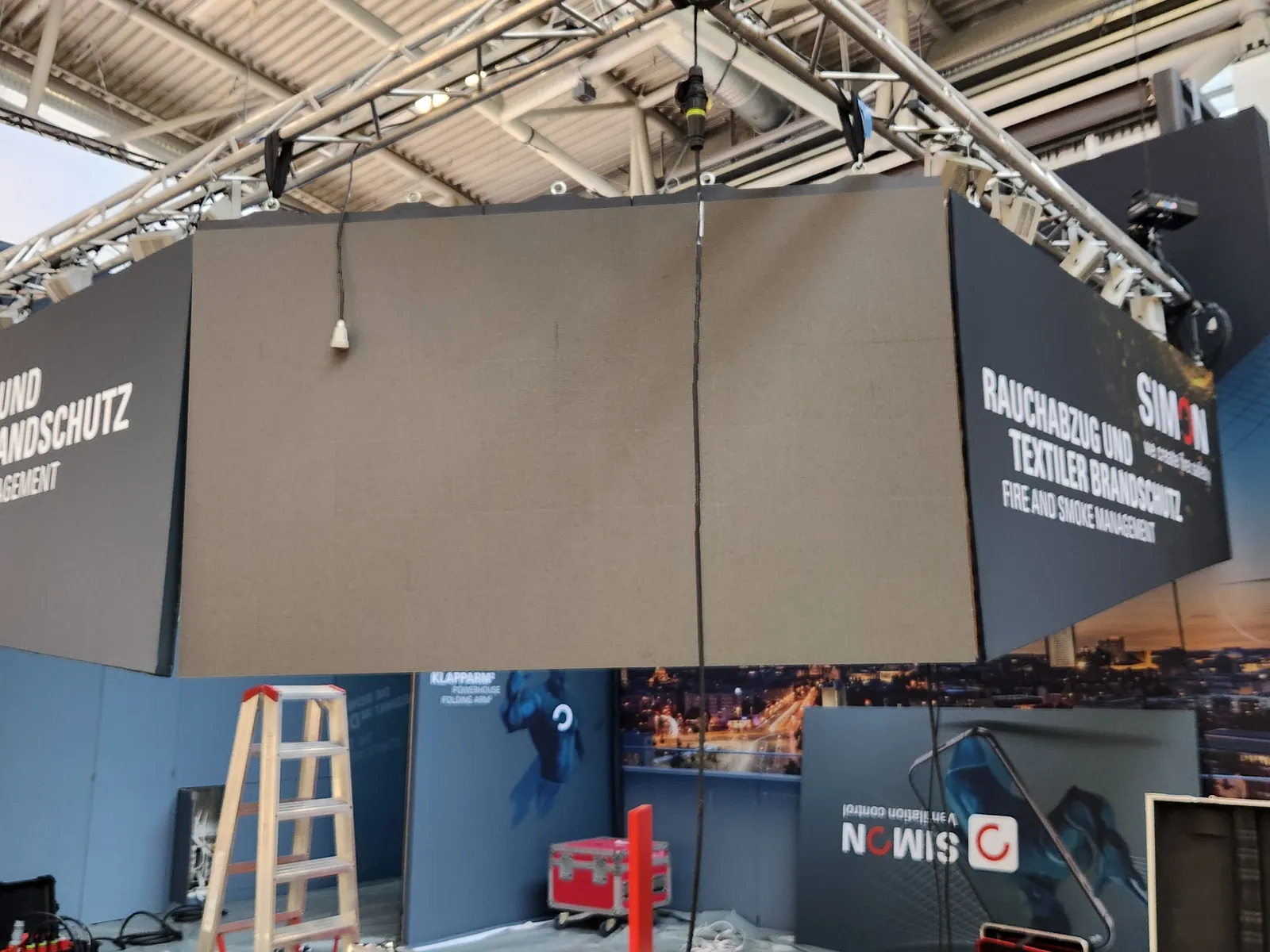 Aufbau einer LED-Wand über einem Messestand, an Traversen abgehängt