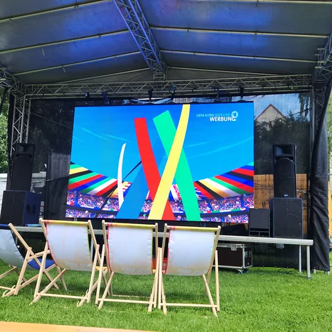 Verleih: LED-Wand auf einer Open-Air-Bühne, davor Liegestühle